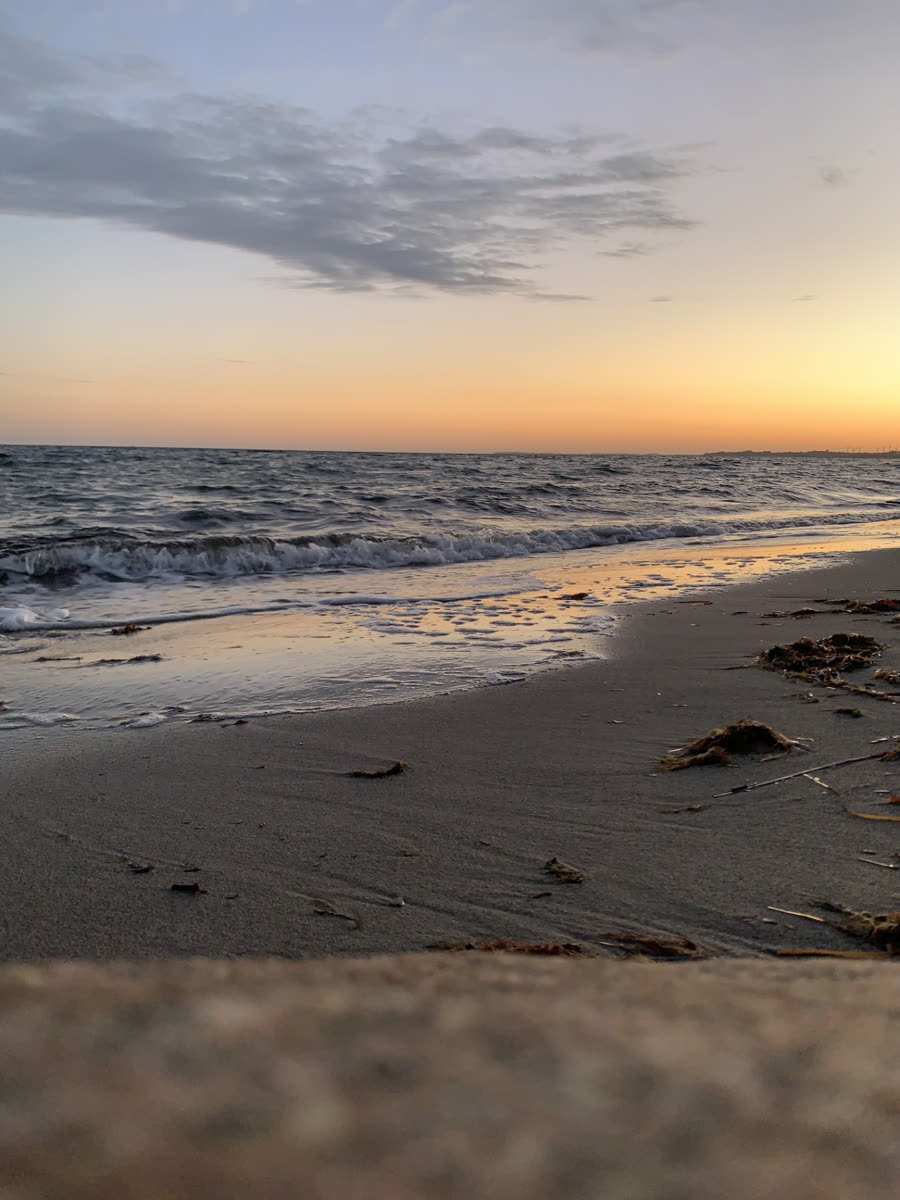 Roligt hav og strand i solnedgang